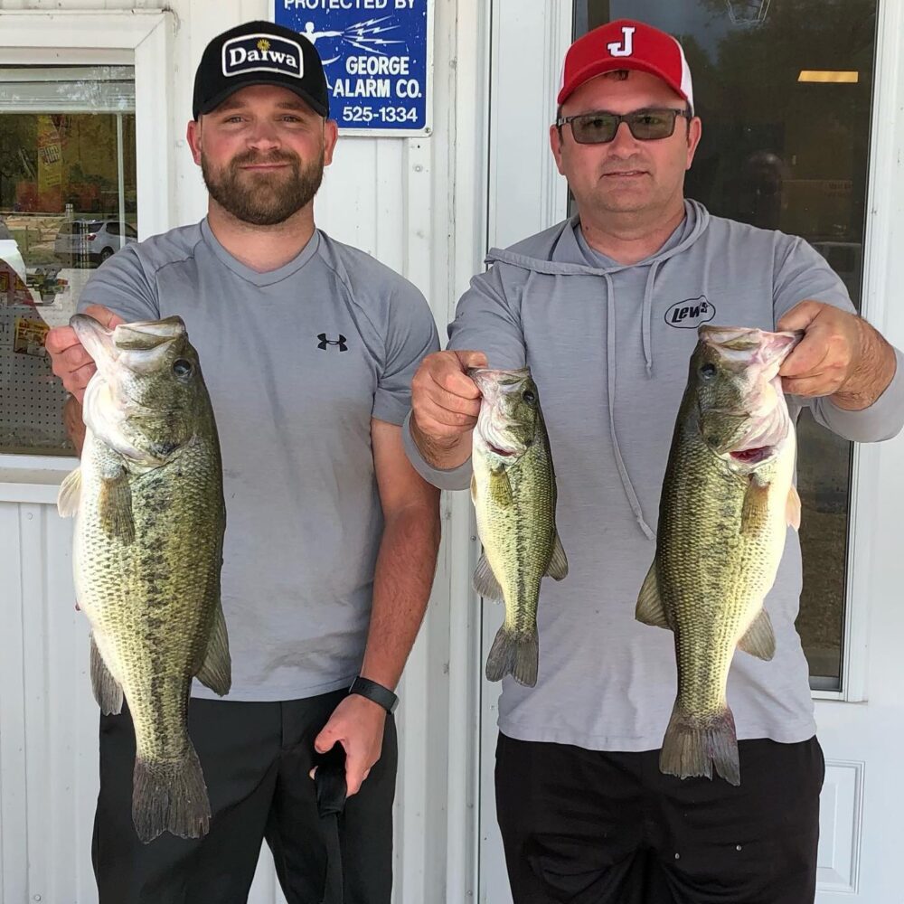 two men holding recently caught fish